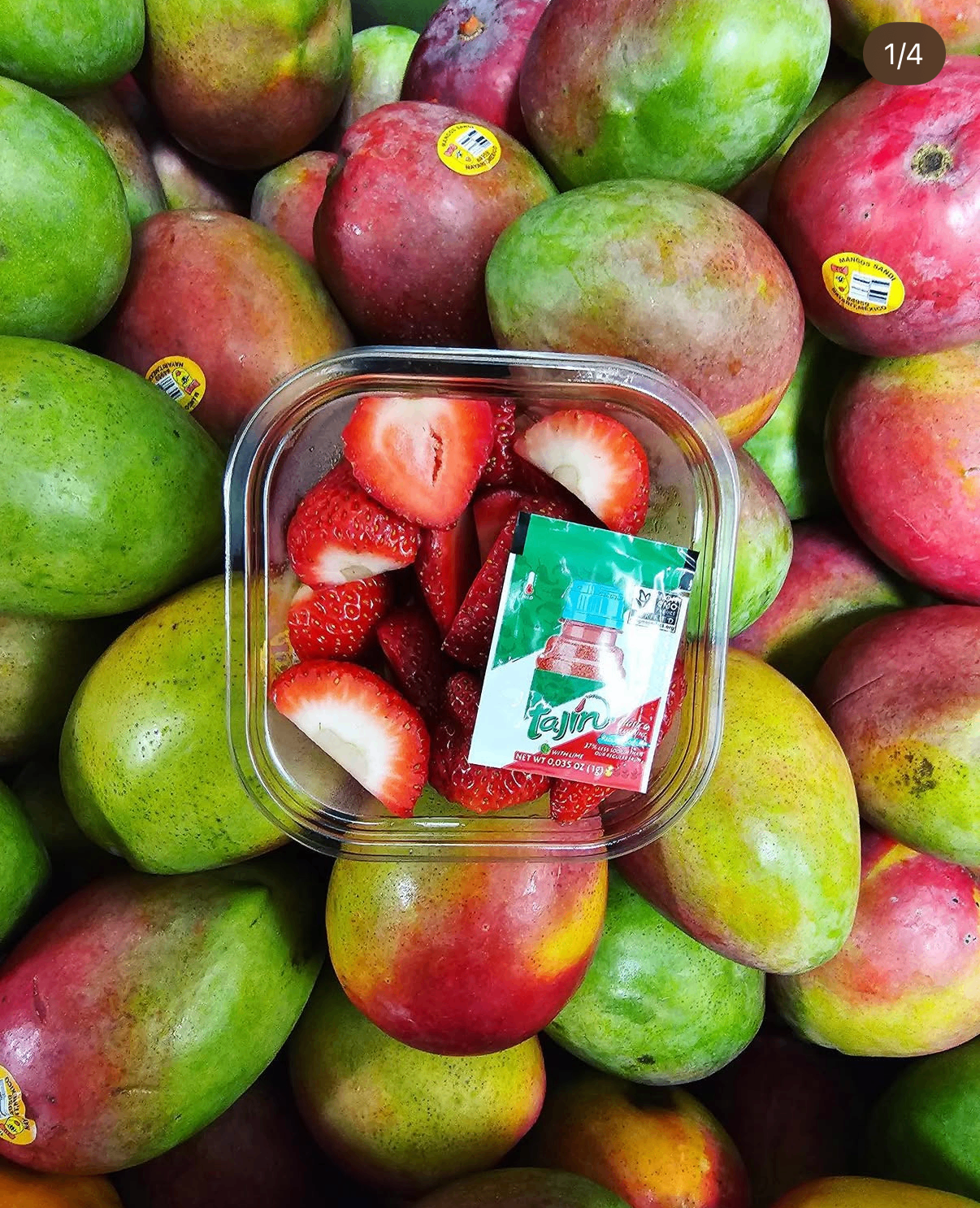 Cup of hand-cut strawberries with Tajin over fresh mangos